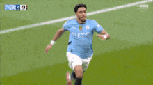 a soccer player in an etihad jersey is kneeling down on the field