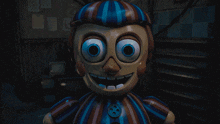 a blue and red clown with a button on his chest
