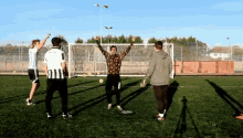 a group of young men are playing soccer on a field and one of them is wearing a striped shirt that says juventus