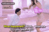 a man is kneeling down next to a woman in a pink top and shorts and asking her what she is wearing .