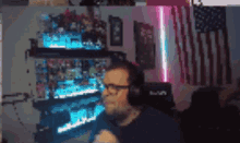 a man wearing glasses and headphones is sitting in front of a computer screen .