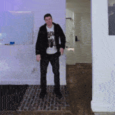 a man wearing a black jacket and a white shirt that says guns n roses