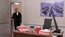 a blurred image of a man standing in a doorway behind a desk