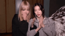 two girls are standing next to each other and making funny faces .