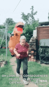 an elderly woman is wearing a t-rex costume and dancing in a garden .