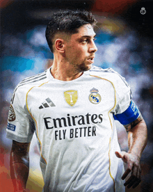 a soccer player wearing a white emirates fly better jersey