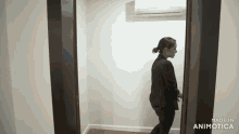 a woman is standing in a room with the words made in animatica on the bottom right