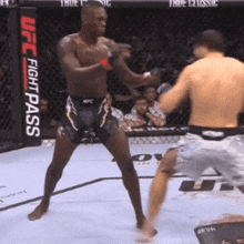 two men are fighting in a boxing ring with a sign that says ufc fight pass