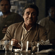 a man is sitting at a bar with a starz logo on the bar