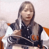 a woman is sitting on a couch holding a book and a knife .