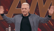 a man with his arms outstretched in front of a sign that says aw