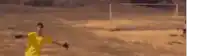 a blurry picture of a man in a yellow shirt making a peace sign