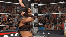 a woman in a wrestling ring with a w logo on the ropes