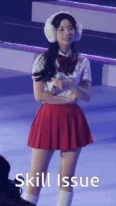 a girl in a red skirt and white shirt is holding a microphone with the words skill issue above her