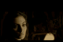 a man and a woman are looking at each other in a dark room in a movie .
