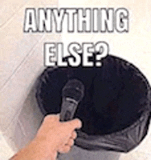 a person is holding a microphone over a trash can .