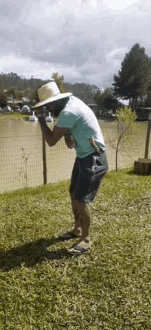 a man wearing a straw hat holds a can of beer