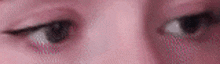 a close up of a woman 's eyes with a pink background