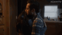 a man and a woman kissing in a kitchen .