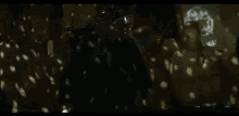 a person in a white coat is standing in a dark room with their arms outstretched .