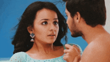 a man and a woman are looking at each other and the woman has earrings on her ear