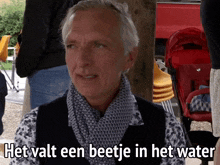 a man says het valt een beetje in het water in front of a red stroller