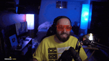 a man with a beard wearing a yellow shirt that says ' bb ' on it