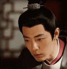a close up of a man 's face with a hair pin in his hair