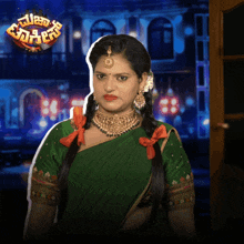 a woman in a green saree stands in front of a sign that says " telugu "