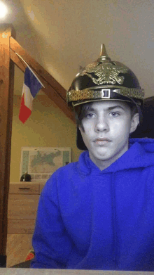 a boy wearing a blue hoodie and a helmet with the letter o on it