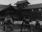 a black and white photo of a group of samurai in front of a building
