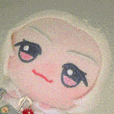a close up of a stuffed animal with white hair and a blue eye