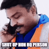 a man with a mustache is talking on a cell phone and says `` shut up non hq person '' .