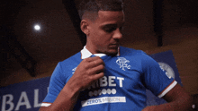 a man in a blue shirt with the word bet on the front