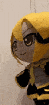 a close up of a stuffed animal with a yellow hair and a black bow .