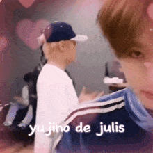 two young men are standing next to each other with the words yu jino de julis written on the bottom of the image .