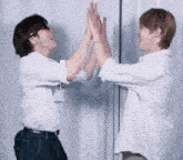 two men are giving each other a high five while wearing sunglasses .