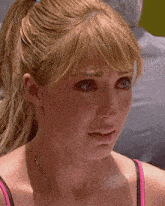 a close up of a woman 's face with a ponytail and a necklace