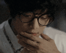 a close up of a person wearing glasses with almighty written on the bottom right