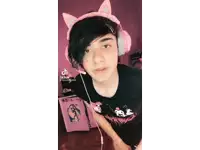 a young man wearing pink headphones and a black shirt with a sticker on it