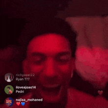 a group of people are sitting in a dark room with red lights behind them and the name ryan is on the top left