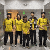 a group of young men wearing yellow nubia shirts stand in a hallway