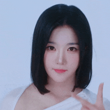 a woman in a white shirt is making a peace sign with her hands