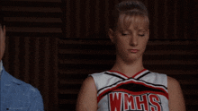 a cheerleader wearing a wmhs uniform is standing next to a man