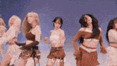 a group of women are dancing in front of a blue sky and the word chow is on the bottom