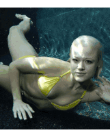 a woman in a yellow bikini is swimming in the water