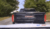 a black gmc truck is driving down a street