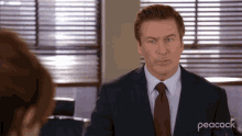 a man in a suit and tie has peacock written on the bottom right