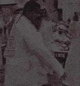 a man in a white shirt is standing next to another man in a white robe