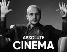 a black and white photo of a man with his hands in the air and the words absolute cinema below him